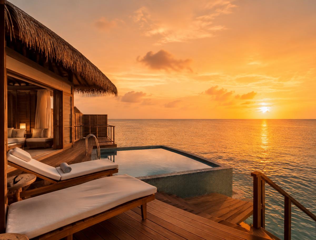 Overwater villa deck at sunset